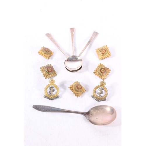 594 - Hallmarked silver spoons, 55g, together with two medical corps cap badges and officers pips