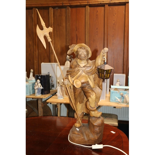 684 - Swiss/German carved wooden figure of a nightwatchman holding halberd and lamp.