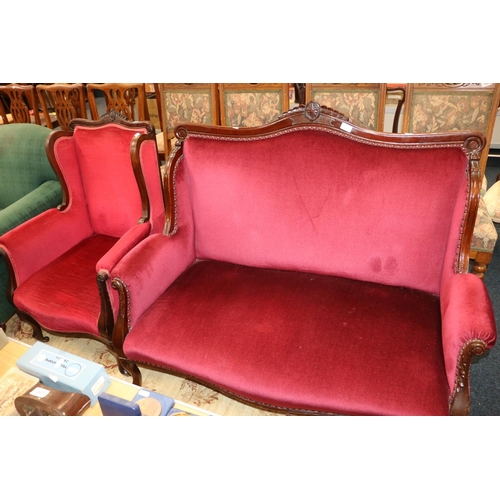 697 - Two piece salon suite comprising sofa and armchair upholstered in burgundy fabric.