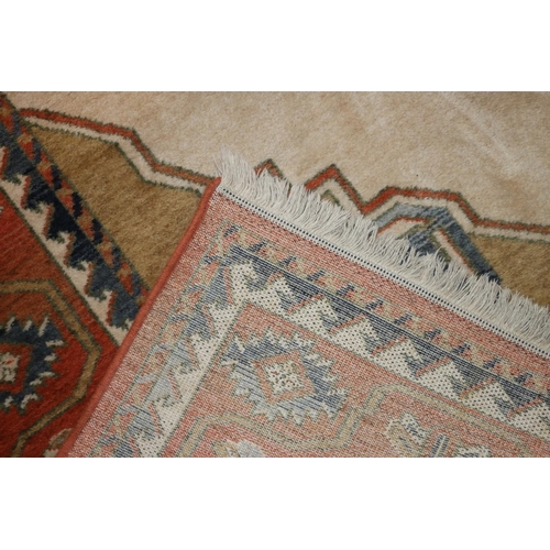 704 - Caucasian rug on cream and rust red ground, 195cm x 280cm.