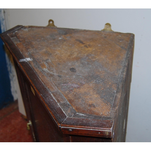 433 - 18th century George III oak corner cupboard, the hinged door enclosing later painted shelving, brass... 