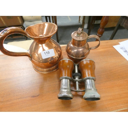 110 - Two copper jugs and a pair of binoculars.