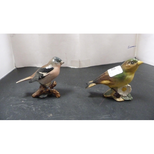 260 - Two small Beswick bird figures of a chaffinch and greenfinch, and a porcelain figure of a cat by Roy... 