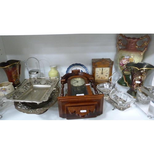 77 - Two clocks, EP cake baskets, EP tea caddy, jug etc (one shelf).