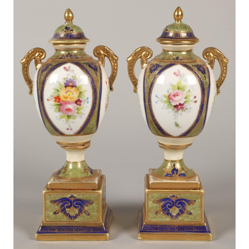 140 - Pair of Noritake twin handled urns and covers, floral decoration on plinth bases 22cm