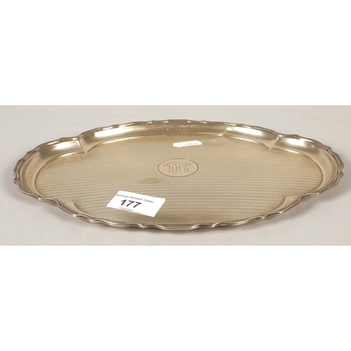 177 - Silver engine turned shaped oval card tray with central monogram 25cm diameter 283 grams