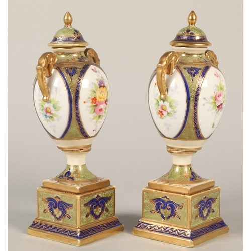 140 - Pair of Noritake twin handled urns and covers, floral decoration on plinth bases 22cm