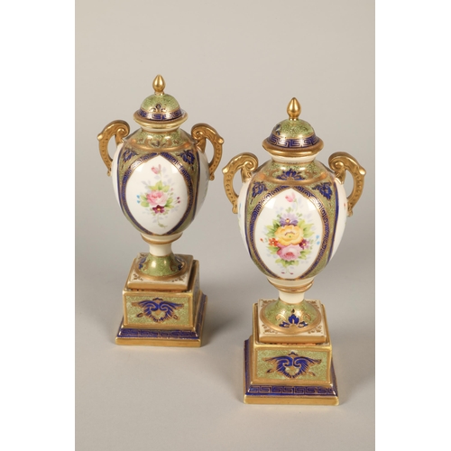 140 - Pair of Noritake twin handled urns and covers, floral decoration on plinth bases 22cm