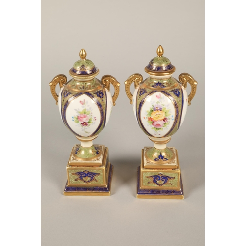 140 - Pair of Noritake twin handled urns and covers, floral decoration on plinth bases 22cm