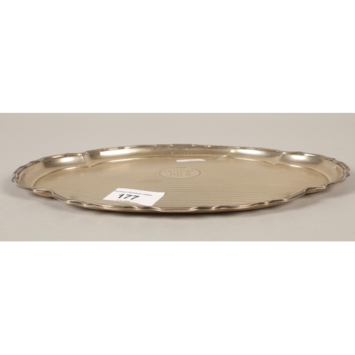 177 - Silver engine turned shaped oval card tray with central monogram 25cm diameter 283 grams