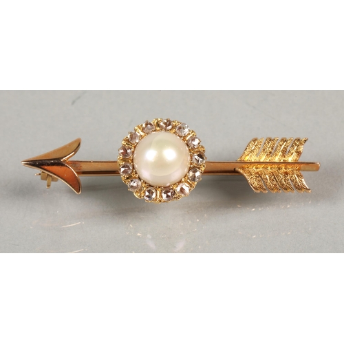 84 - Gold arrow shaped brooch with central pearl surrounded by diamonds