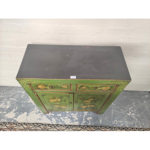 495 - Indian style green painted and lacquered decoupage cupboard with two small drawers above cupboard ba... 