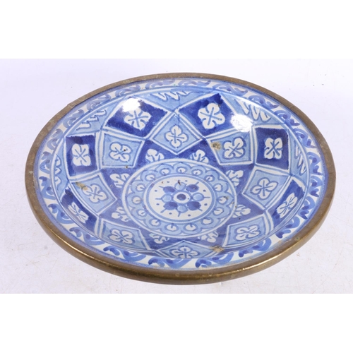 105 - Middle Eastern Iznik style blue and white ceramic bowl with pewter rim, 25.5cm wide.