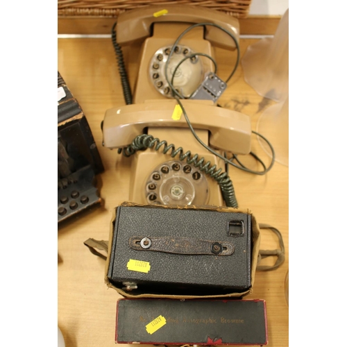 217 - Two 1970s brown plastic telephones, a folding Brownie camera and another camera.