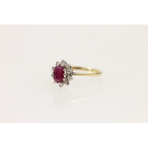 505 - 18ct gold ruby and diamond cluster ring, the central oval ruby surrounded by a halo of 10 round cut ... 