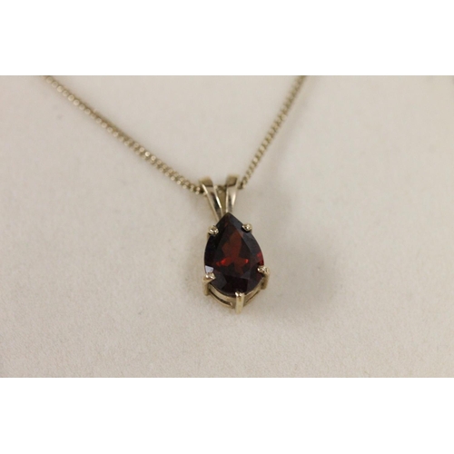 509 - 9ct gold and pear cut red stone pendant on gold chain, 2.6g