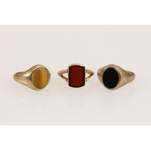 516 - Three 9ct gold rings set with onyx, carnelian and tigers eye, 6.7g