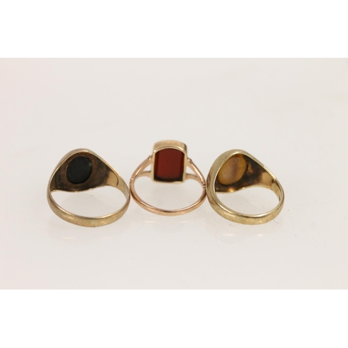 516 - Three 9ct gold rings set with onyx, carnelian and tigers eye, 6.7g