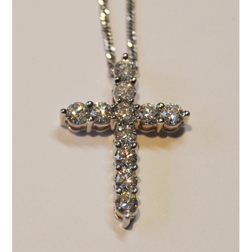 95 - Cross pendant with eleven diamond brilliants, in white gold (2.7g), platinum necklet, 5.8g in all.