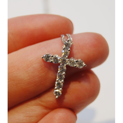 95 - Cross pendant with eleven diamond brilliants, in white gold (2.7g), platinum necklet, 5.8g in all.