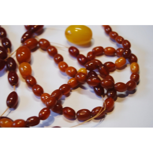 106 - Amber bead necklet of graduated variegated colours, partly un-strung, 84g.