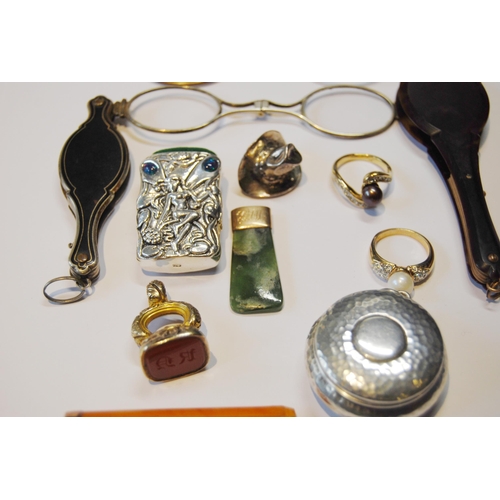 119 - Two lorgnettes, a gold-mounted amber cigarette holder, 1926, silver vesta, seal fob, greenstone pend... 