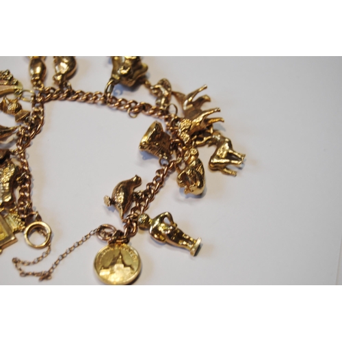 147 - Gold curb bracelet with various charms, mostly 9ct, 58.8g gross.