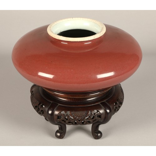 216 - Chinese porcelain red squat vase on hardwood carved stand 10 cm high (not including stand).