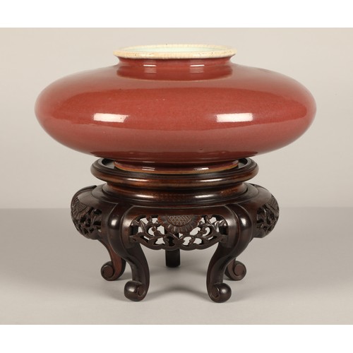 216 - Chinese porcelain red squat vase on hardwood carved stand 10 cm high (not including stand).