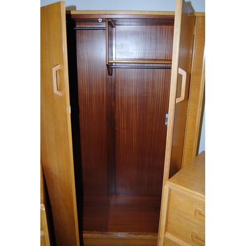 438 - Ernest Gomme for G Plan 1960s light oak three-piece bedroom suite comprising a two-door wardrobe, ch... 