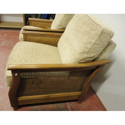 447 - Ercol teak and bergère three-piece suite comprising a large settee and a pair of armchairs, fabric-c... 