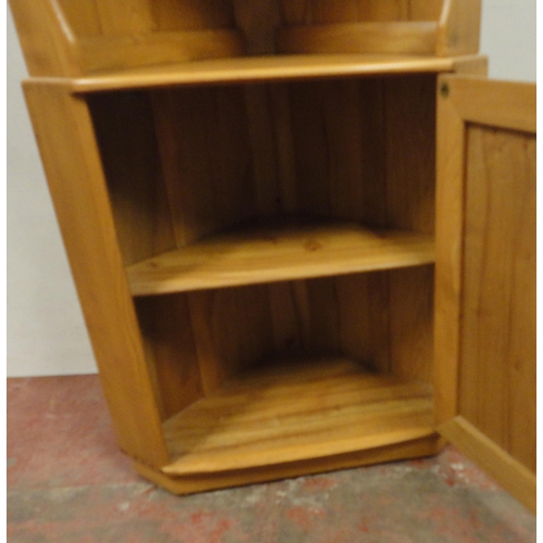 450 - Ercol blonde elm Windsor corner unit with open shelving above a cupboard door, enclosing a shelved i... 