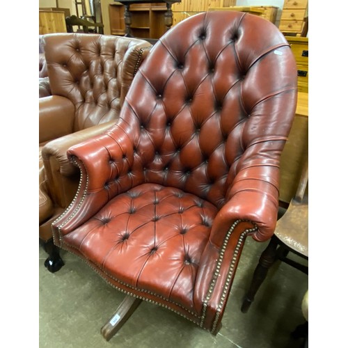 568 - Red leather Chesterfield-style swivel chair, approx. 110cm