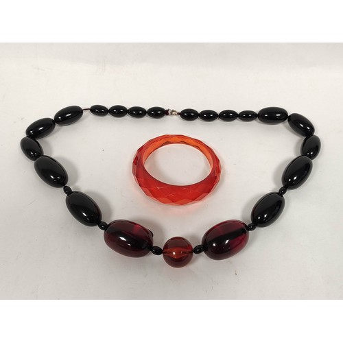 163 - Amber bead necklace of graduated oval beads and a faceted bangle.