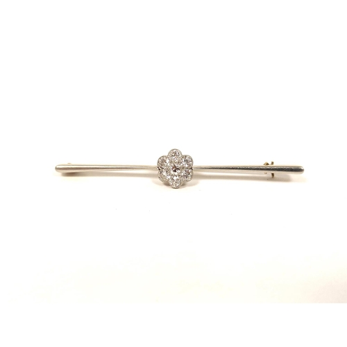 143 - Diamond seven stone cluster brooch in platinum and gold '15ct' 5.5g, 3g