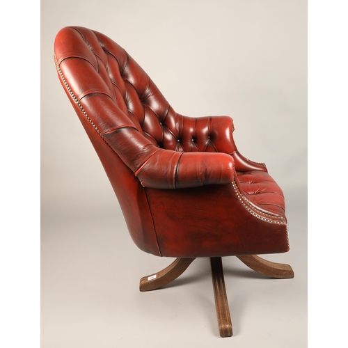 568 - Red leather Chesterfield-style swivel chair, approx. 110cm