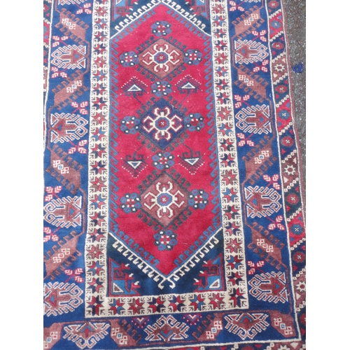 414 - Turkish Belouch hand-knotted rug with three geometric lozenges to the centre, flanked by a band of f... 