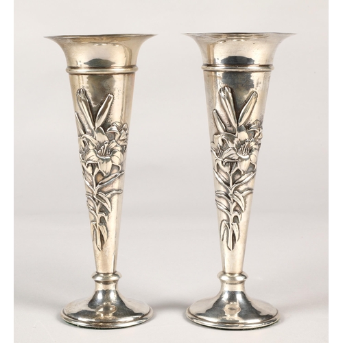 175 - Pair of silver weighted spill vases, with embossed floral decoration, assay marked London 1906,maker... 