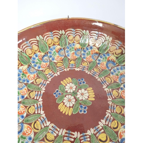 336 - Continental painted terracotta circular dish, In the manner of Thun of Switzerland, decorated with c... 