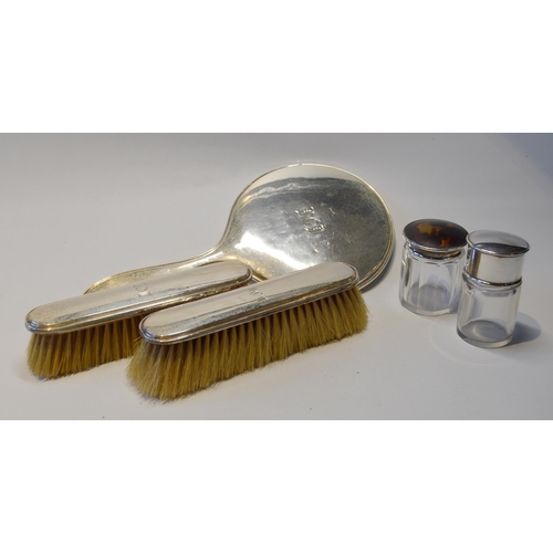 75 - Silver hand mirror, a pair of clothes brushes and two toilet jars.