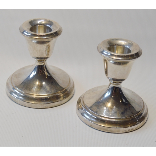 78 - Pair of silver dwarf candlesticks, loaded, and a pair of silver spoons, cased.