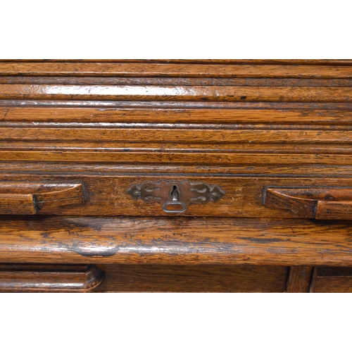 474 - Oak roll-top desk, c. 1930s, with tambour roller shutter enclosing drawers and pigeonholes, above th... 