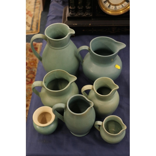 120 - Buchan of Portobello green glazed jugs and a vase, largest 19cm high.