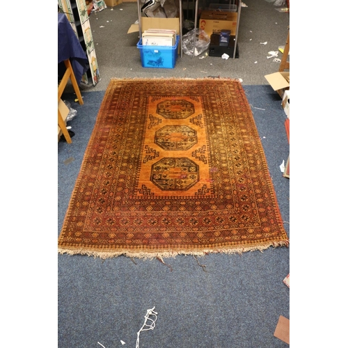 391 - Afghan rust red rug with geometric designs, 190cm x 133cm.