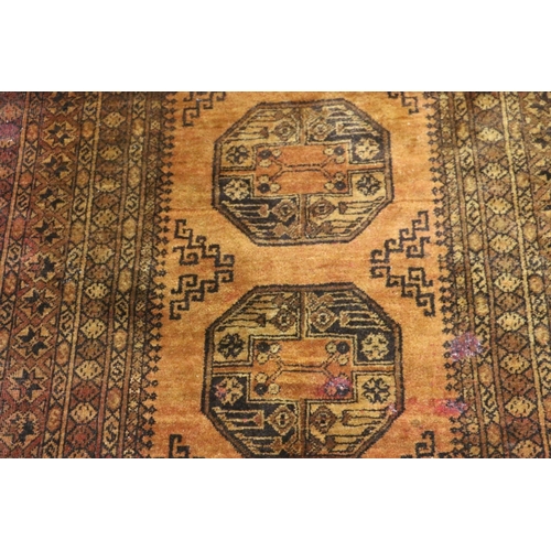 391 - Afghan rust red rug with geometric designs, 190cm x 133cm.