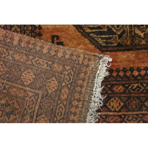 391 - Afghan rust red rug with geometric designs, 190cm x 133cm.