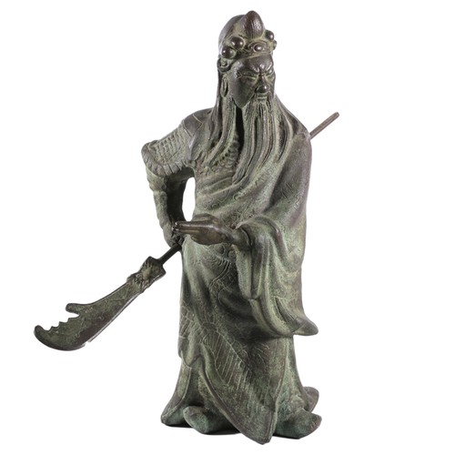 Mid-20th century Chinese patinated bronze figure of an Immortal Warrior holding a weapon.