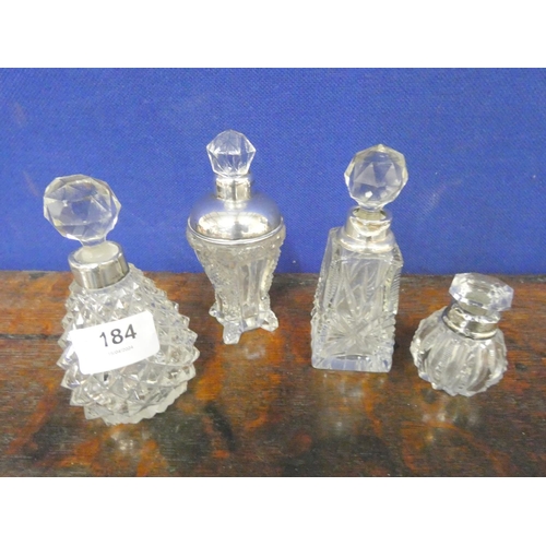 184 - Four cut glass antique silver rim scent bottles.