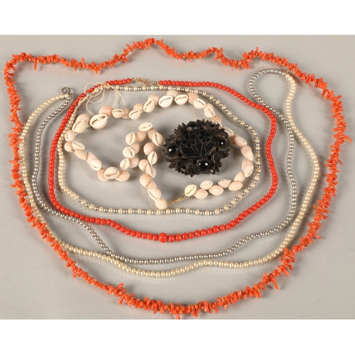 72 - Two coral necklaces, two pearl necklaces, shell necklace, and jet brooch