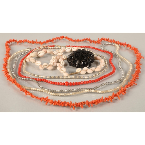 72 - Two coral necklaces, two pearl necklaces, shell necklace, and jet brooch